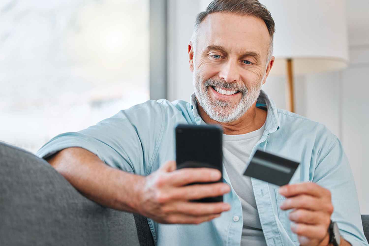 Mann mit Mobiltelefon und Kreditkarte