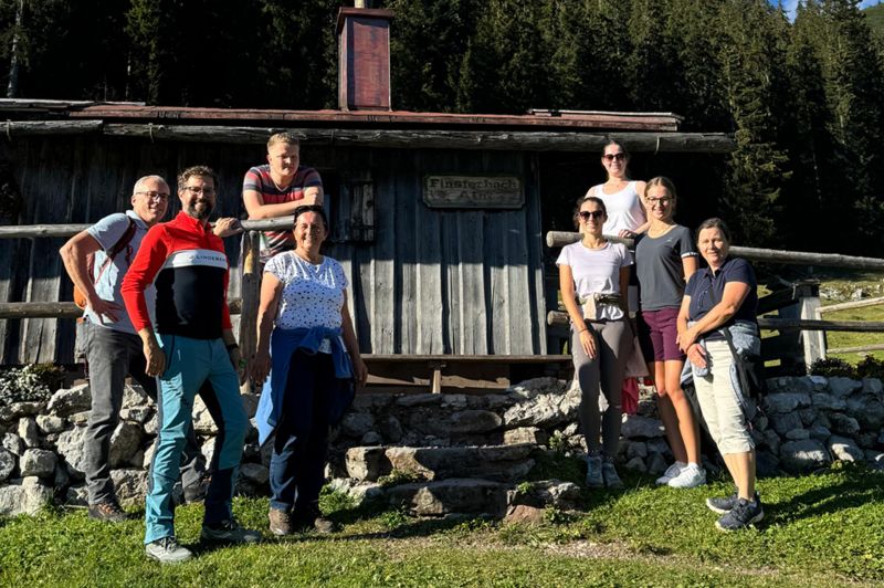 Mitarbeiter stehen vor einer Hütte in den Berger